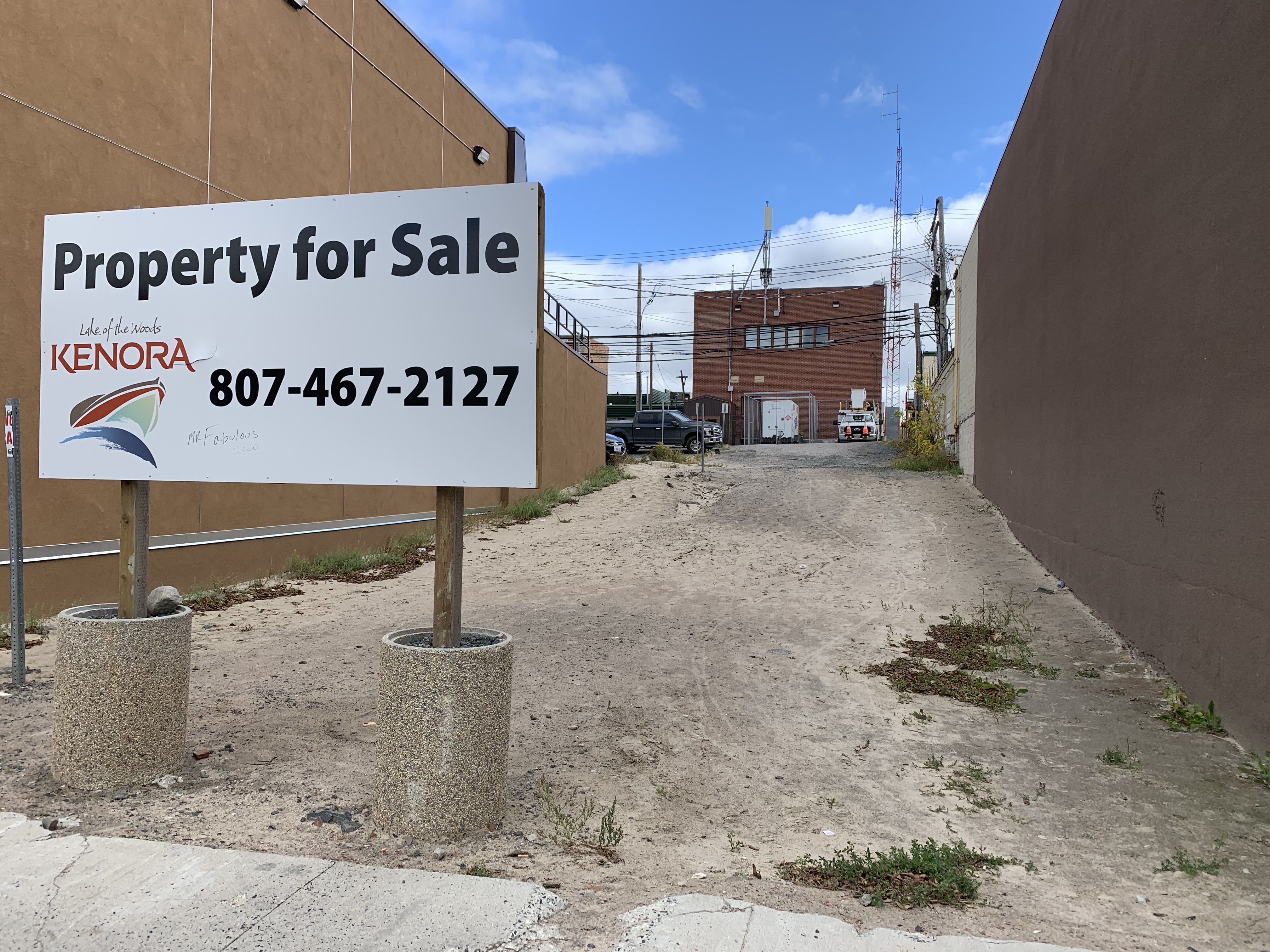 vacant property between two buildings with for sale sign